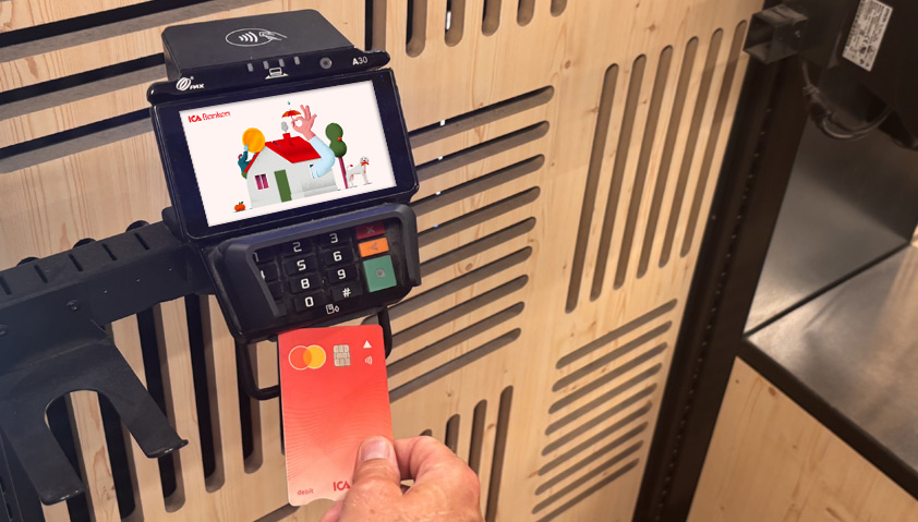 Person som betalar med ICA Bankens bankkort i en betalterminal på ICA.